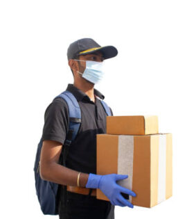 Portrait Of Young Indian Delivery Man Holding Cardboard Box